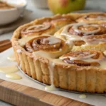 Cinnamon Roll Apple Pie topped with glaze.