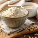 Oat flour recipes featuring a bowl of oat flour with oats and a wooden spoon.