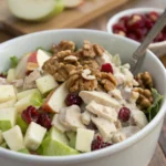 Chicken and Apple Salad with walnuts and cranberries in a bowl